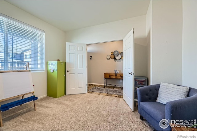 sitting room featuring vaulted ceiling, carpet flooring, and baseboards