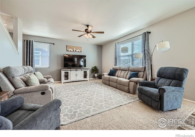 living room with carpet floors, ceiling fan, and baseboards