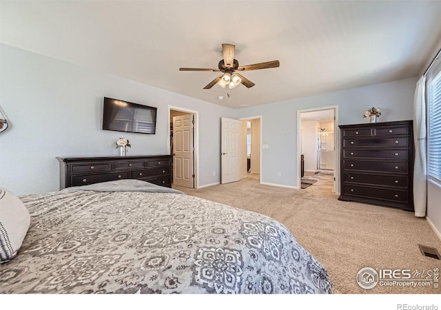 carpeted bedroom featuring a ceiling fan, visible vents, baseboards, and ensuite bathroom