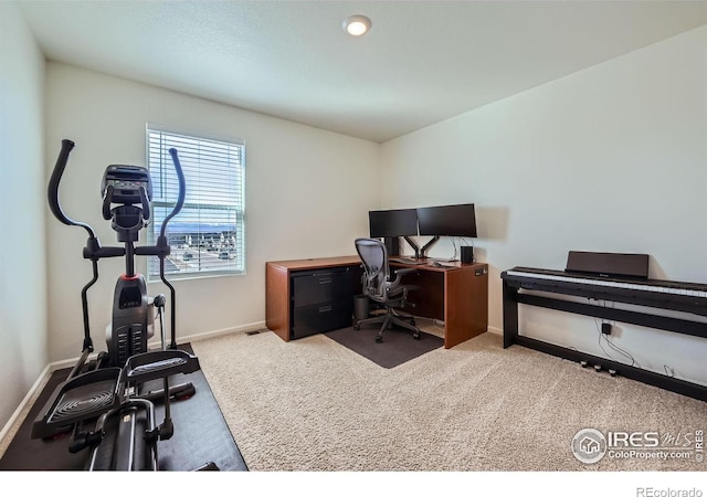 carpeted home office with baseboards