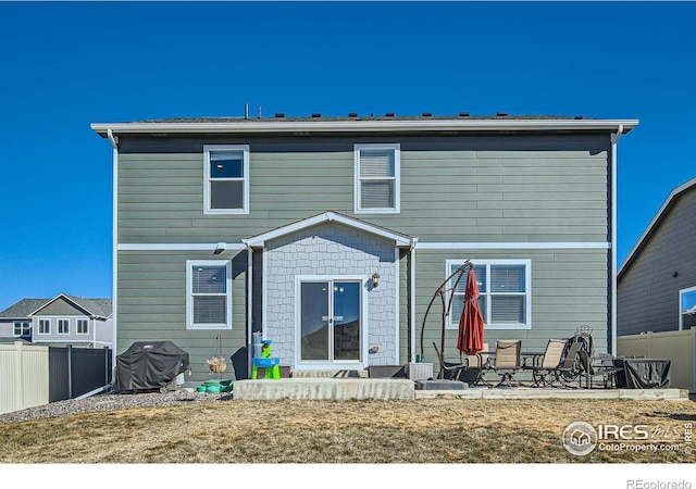 back of property featuring a patio area and fence