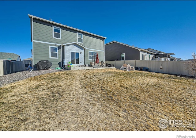 rear view of property with a yard, a fenced backyard, and a patio