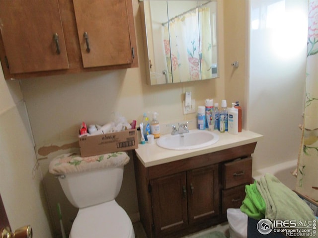 full bath featuring a shower with shower curtain, vanity, and toilet