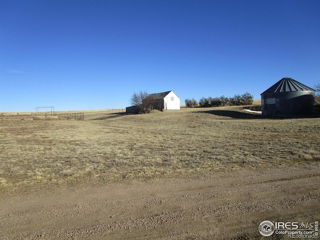 view of yard with an outbuilding and a rural view