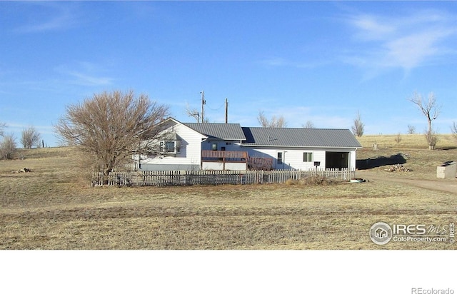 view of front of home with a fenced front yard and metal roof