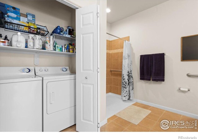 laundry room with light tile patterned floors, laundry area, washing machine and dryer, and baseboards