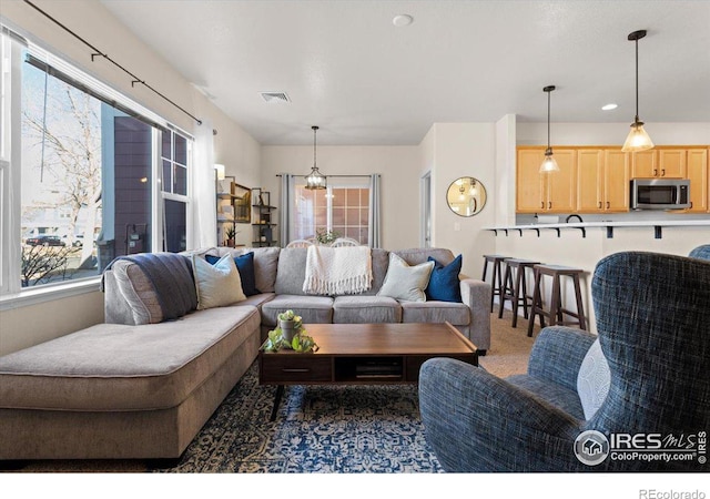 carpeted living area with visible vents and recessed lighting