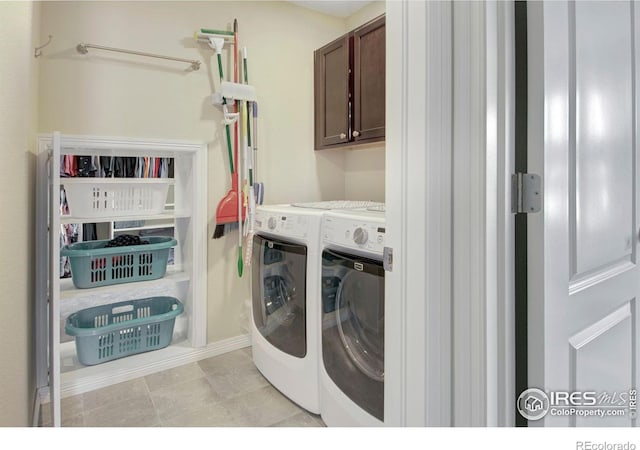 washroom with cabinet space and washing machine and clothes dryer