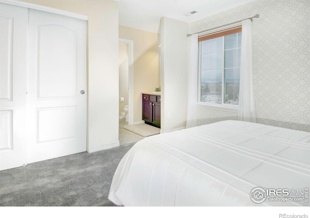 bedroom featuring wallpapered walls, carpet, visible vents, and ensuite bathroom