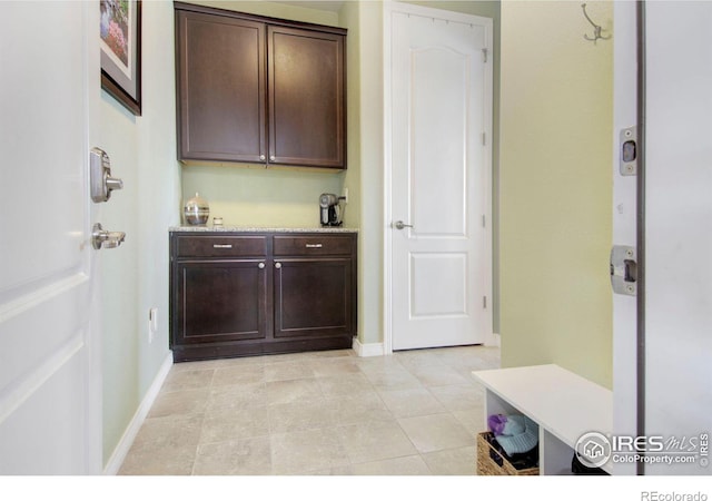 interior space featuring baseboards and dark brown cabinets