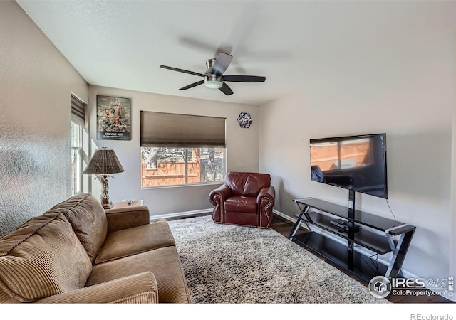 living room with ceiling fan, wood finished floors, and baseboards