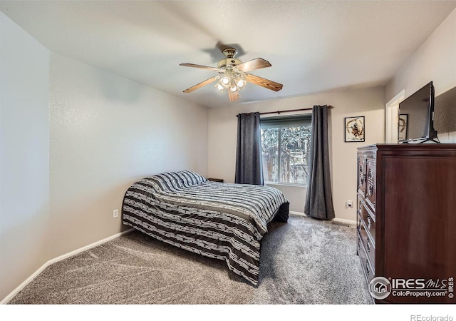 carpeted bedroom featuring baseboards and a ceiling fan