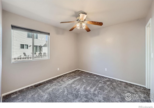 carpeted empty room featuring a ceiling fan and baseboards