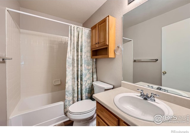 full bathroom featuring shower / tub combo, a textured wall, vanity, and toilet