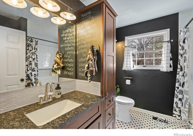 bathroom with vanity, toilet, and baseboards