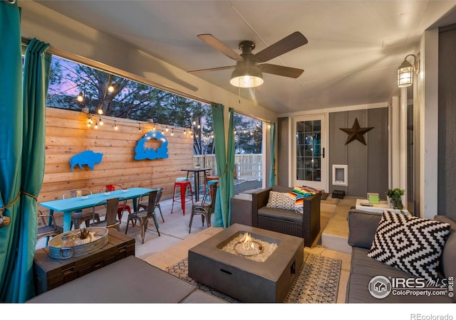 view of patio / terrace with an outdoor living space with a fire pit, outdoor dining area, fence, and a ceiling fan