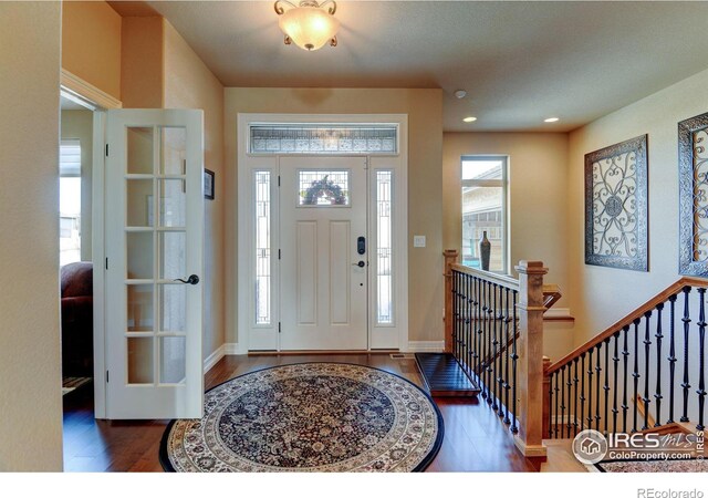 foyer entrance featuring recessed lighting, plenty of natural light, baseboards, and wood finished floors