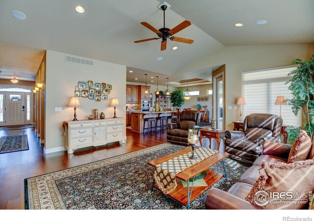 living room featuring a wealth of natural light, dark wood-type flooring, and visible vents