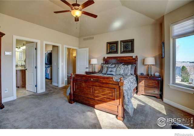 carpeted bedroom featuring lofted ceiling, visible vents, a spacious closet, a ceiling fan, and baseboards