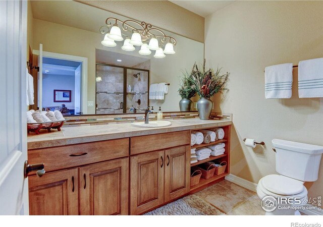 full bath with a stall shower, vanity, toilet, and tile patterned floors