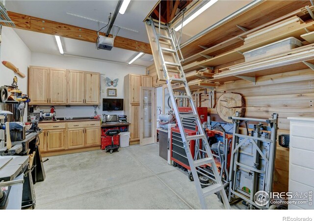 garage featuring a garage door opener and a workshop area