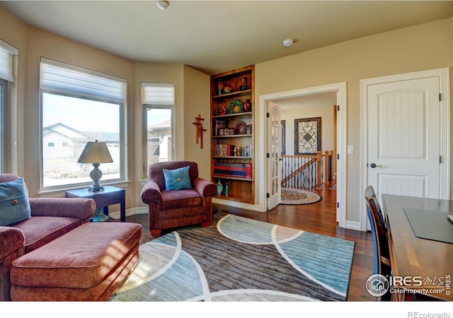 living room with dark wood-type flooring and baseboards