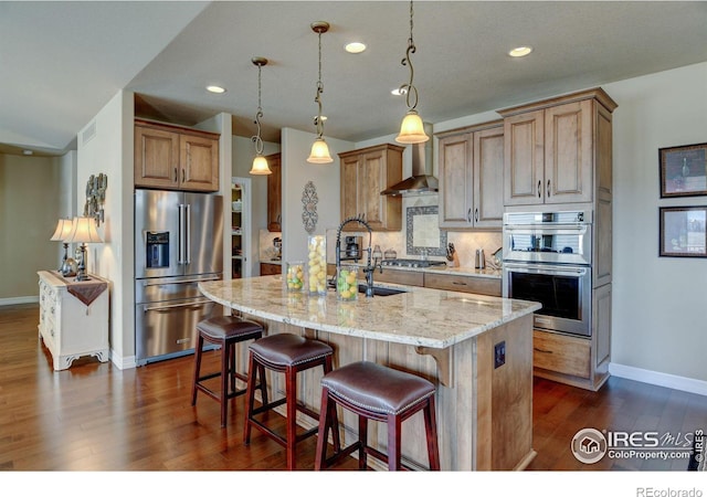 kitchen featuring a breakfast bar, stainless steel appliances, tasteful backsplash, light stone countertops, and wall chimney exhaust hood