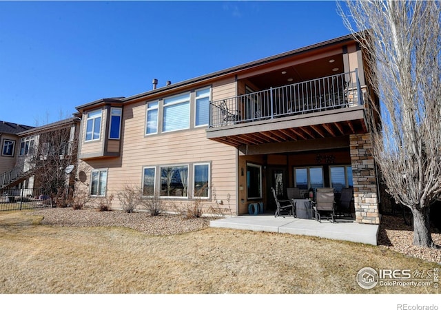 back of property featuring a balcony and a patio area