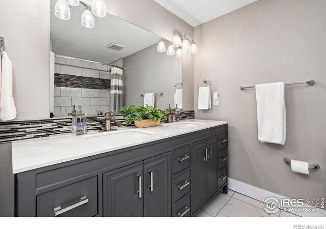 full bath with marble finish floor, visible vents, a sink, and baseboards