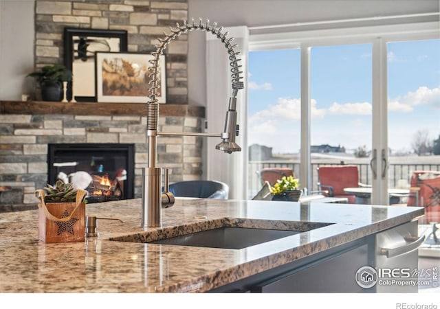 kitchen with stone counters, a healthy amount of sunlight, and a fireplace