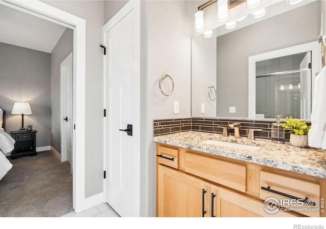 full bath with tile patterned floors, baseboards, an enclosed shower, and vanity