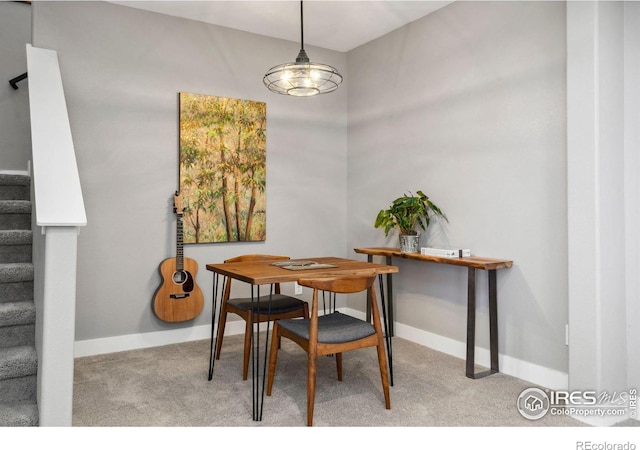 carpeted dining area featuring baseboards and stairway