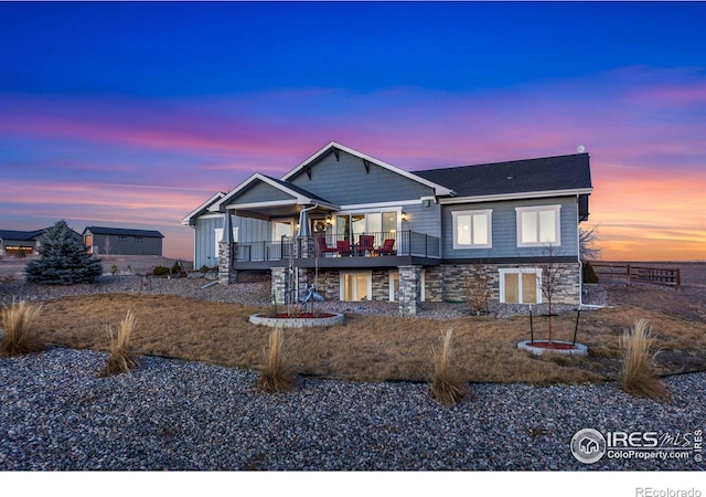 view of front of house featuring stone siding and fence