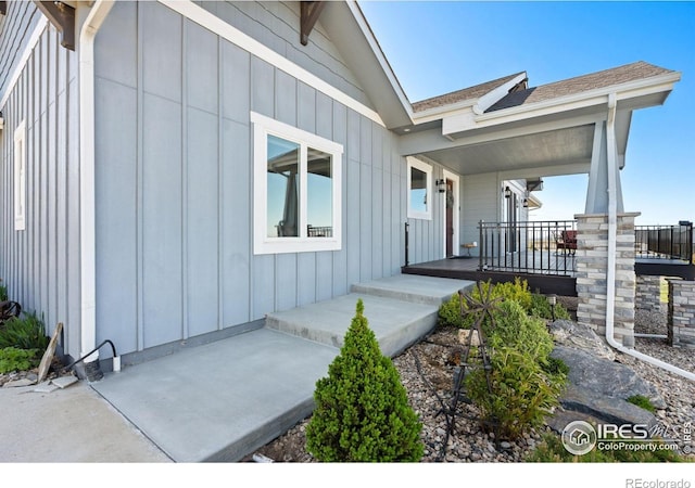 exterior space with a porch, a shingled roof, and board and batten siding