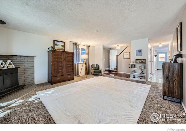 bedroom featuring carpet floors, a fireplace, and a textured ceiling