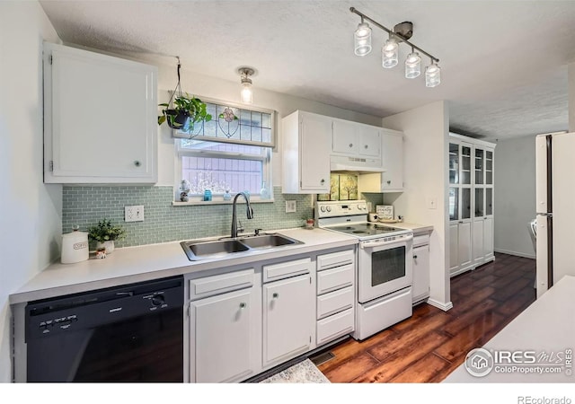 kitchen with white appliances, decorative backsplash, under cabinet range hood, white cabinetry, and a sink