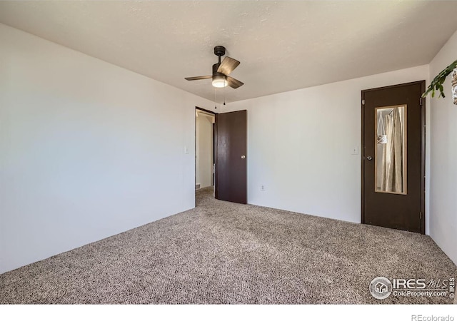 spare room with carpet floors and a ceiling fan