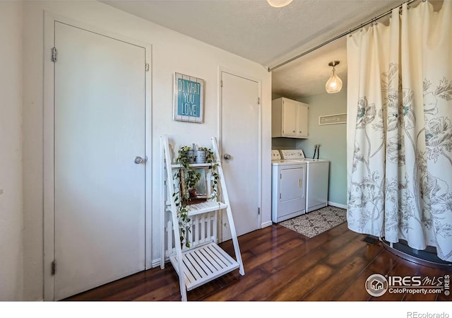 laundry room with a textured ceiling, independent washer and dryer, wood finished floors, and cabinet space