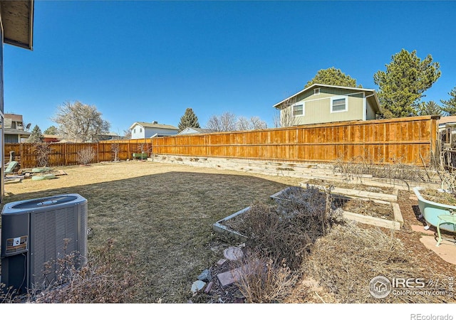 view of yard with central air condition unit and a fenced backyard