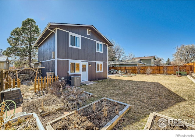 back of property featuring a garden, a patio, central AC, and a fenced backyard