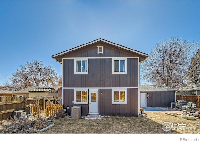 traditional-style home with central AC unit, fence, and a patio