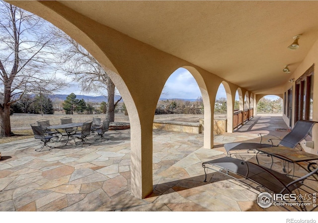 view of patio / terrace with outdoor dining area and a mountain view