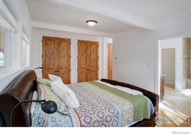 bedroom with ensuite bathroom and two closets