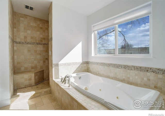 bathroom featuring visible vents, a whirlpool tub, and tiled shower