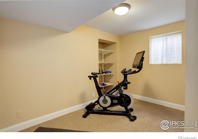 workout area featuring built in shelves, carpet, and baseboards