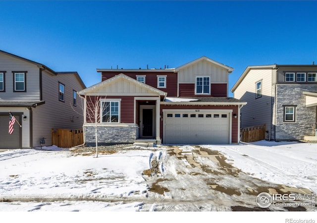 view of front of home with board and batten siding, fence, and a garage