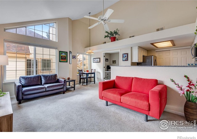 living room featuring a healthy amount of sunlight, ceiling fan, visible vents, and carpet flooring