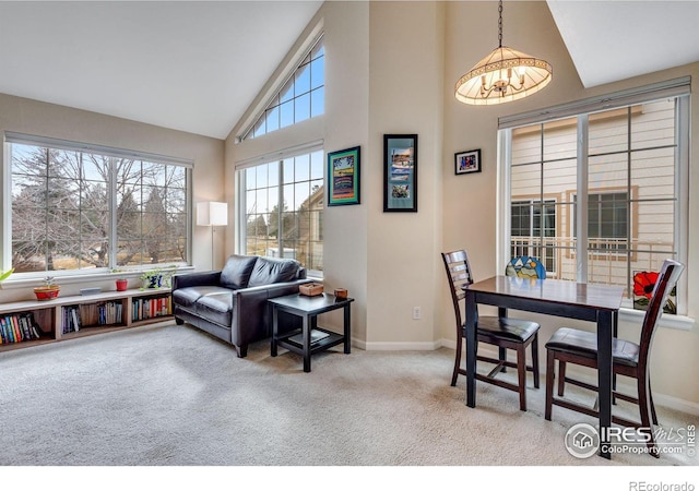 dining room with high vaulted ceiling, carpet, baseboards, and an inviting chandelier