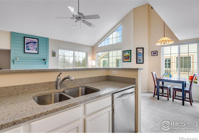 kitchen featuring white cabinets, dishwasher, light colored carpet, light stone counters, and a sink