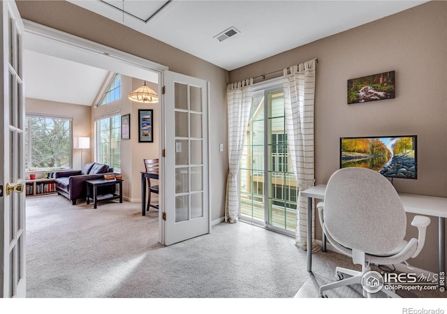 carpeted home office with lofted ceiling, french doors, visible vents, and baseboards